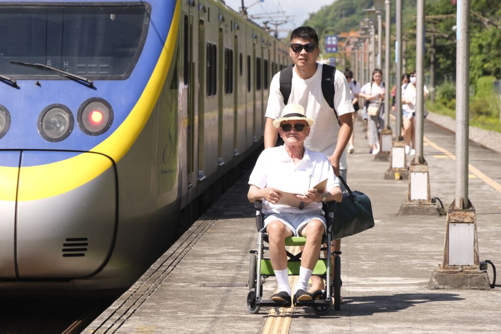 man-in-a-wheelchair-and-his-attendant-waiting-the-train-on-the-plaform