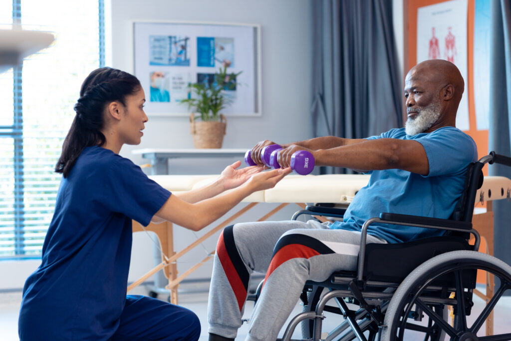 man-in-wheelchair-doing-excercise-with-assistance-from-the-therapist