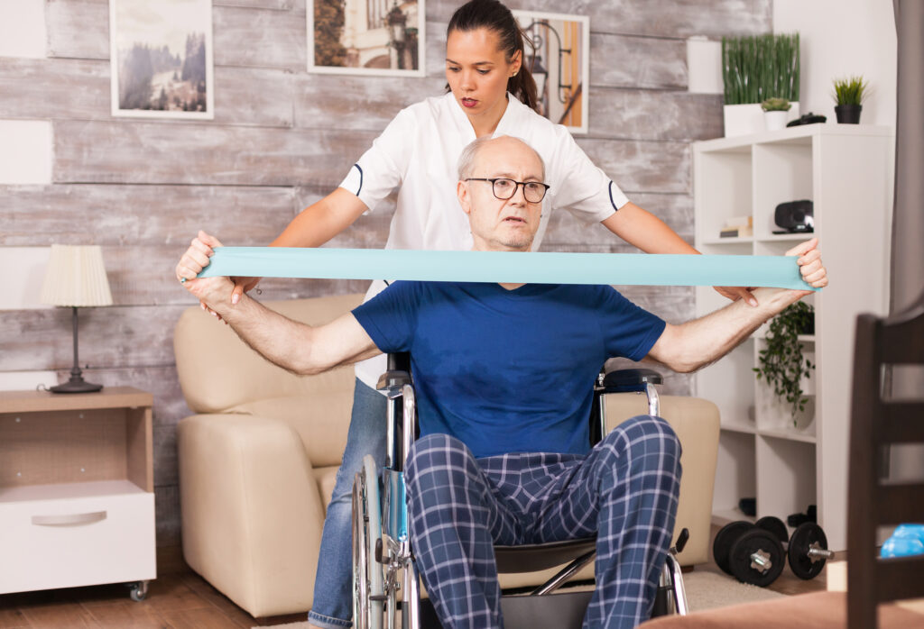 An-elder-in-a-wheelchair-stretching-his-upper-body-with-resistance-band