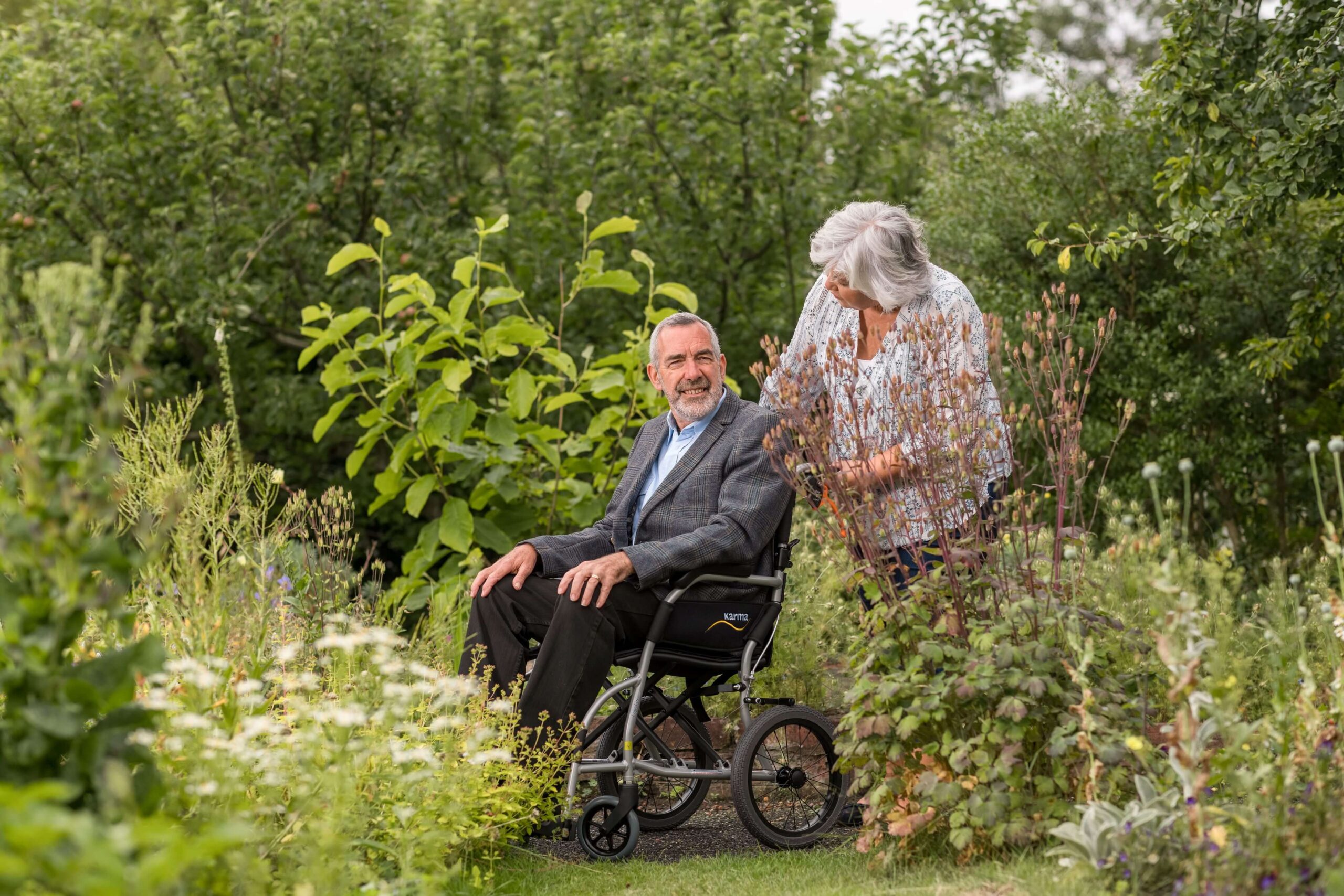 An-elder-sitting-in-a-wheelchair-accompanied-by-his-partner