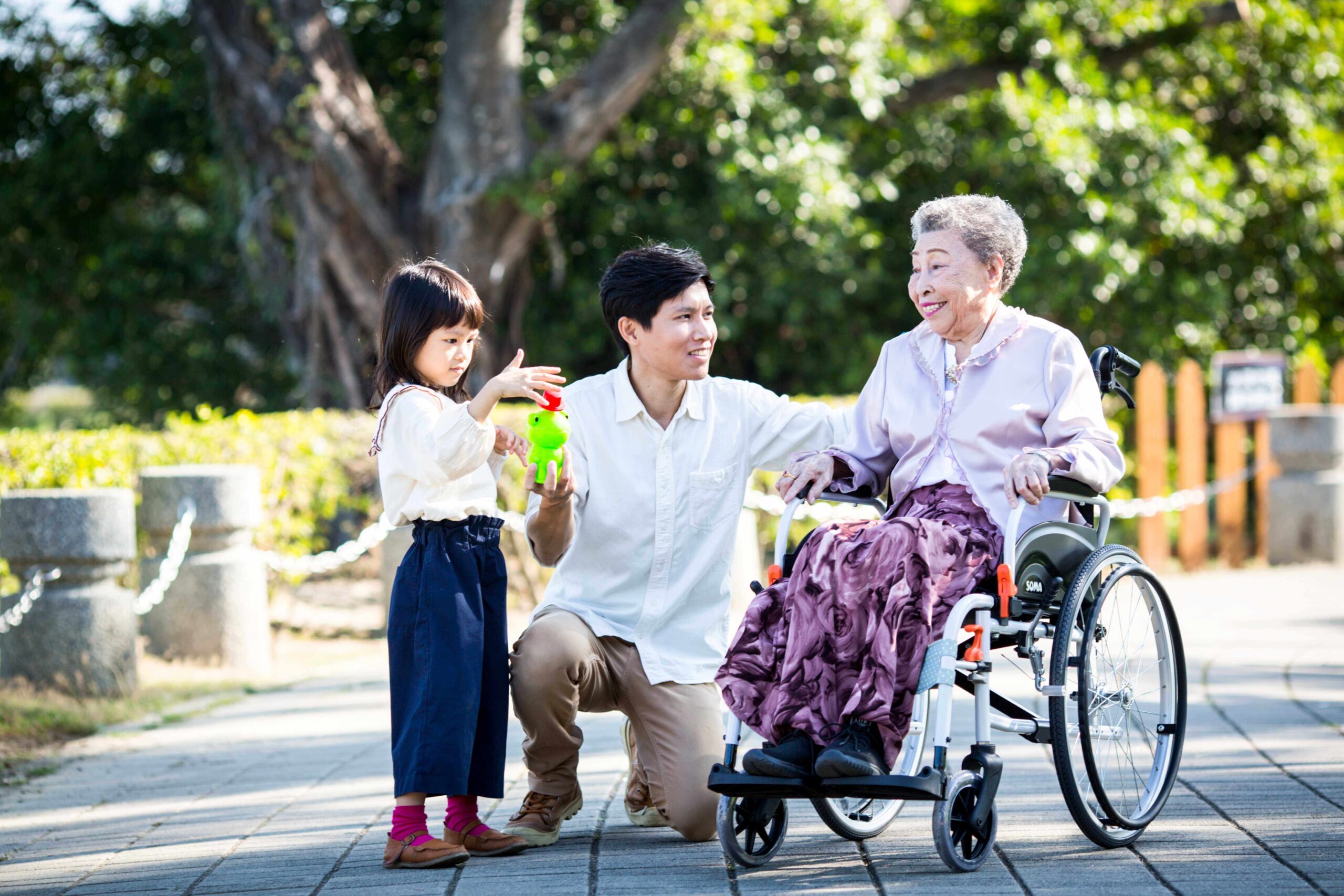 An-elder-lady-in-a-wheelchair-enjoys-her-time-with-her-family-in-a-park