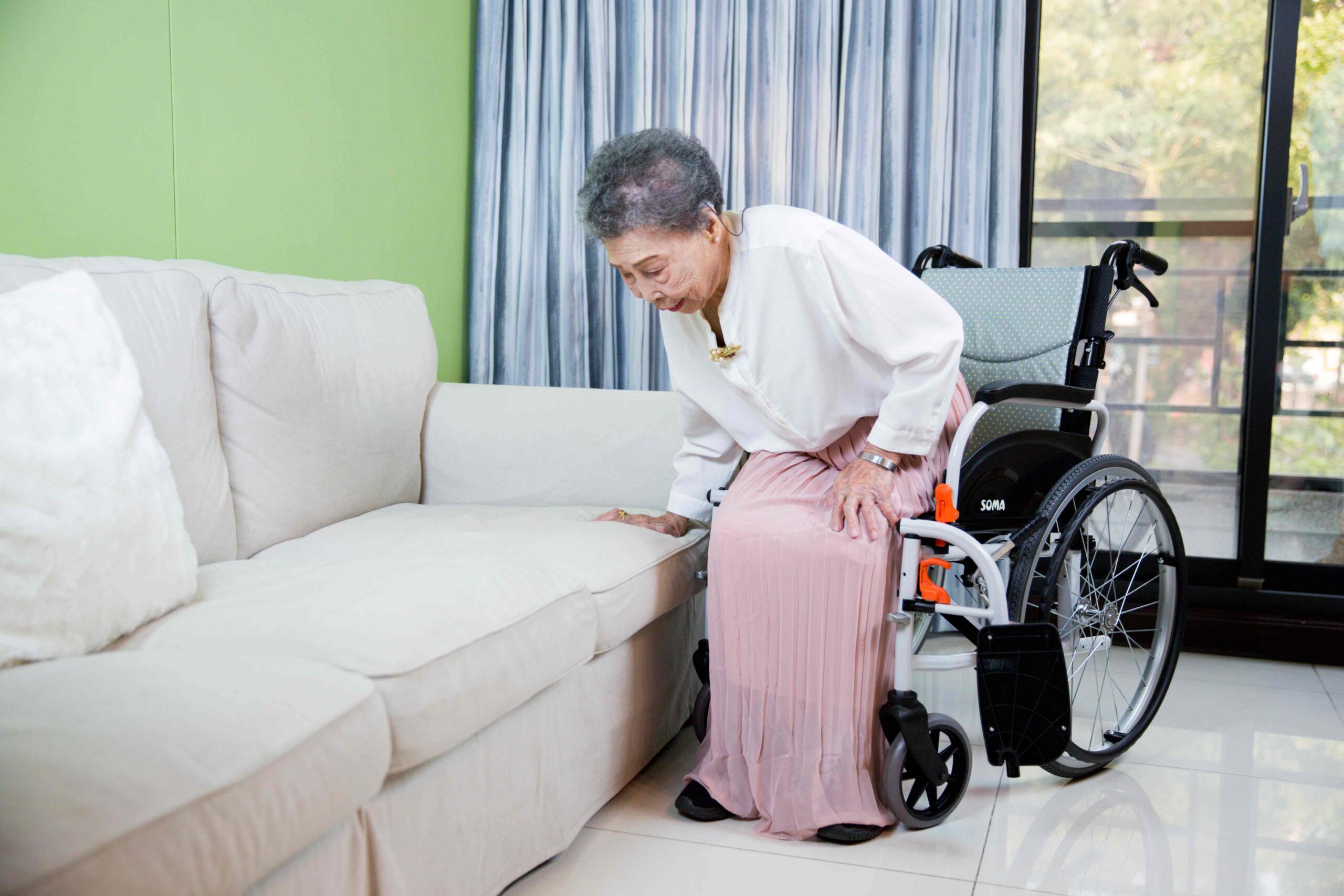 The-legrests-of-the-wheelchair-are-swung-away-so-that-the-elder-can-transfer-herself-safer-and-easier