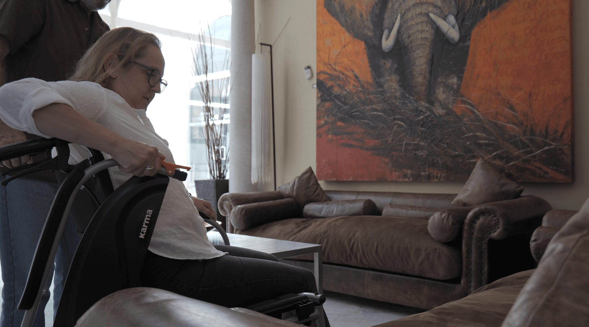 Woman-in-wheelchair-flipping-up-the-armrest-so-that-she-can-be-transferred-more-easier