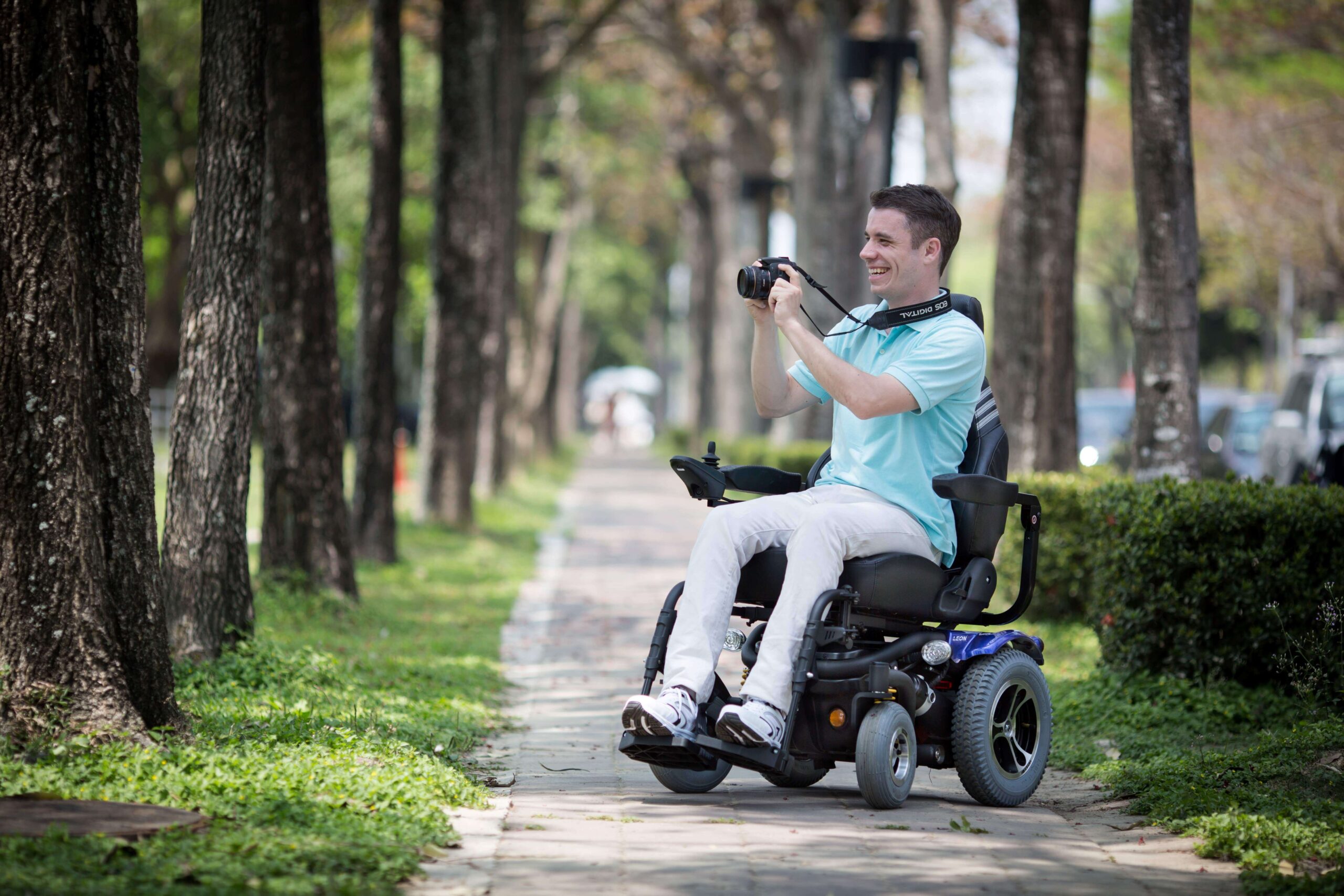 A-man-in-a-wheelchair-holding-a-camera-and-taking-photos-of-the-scenaries