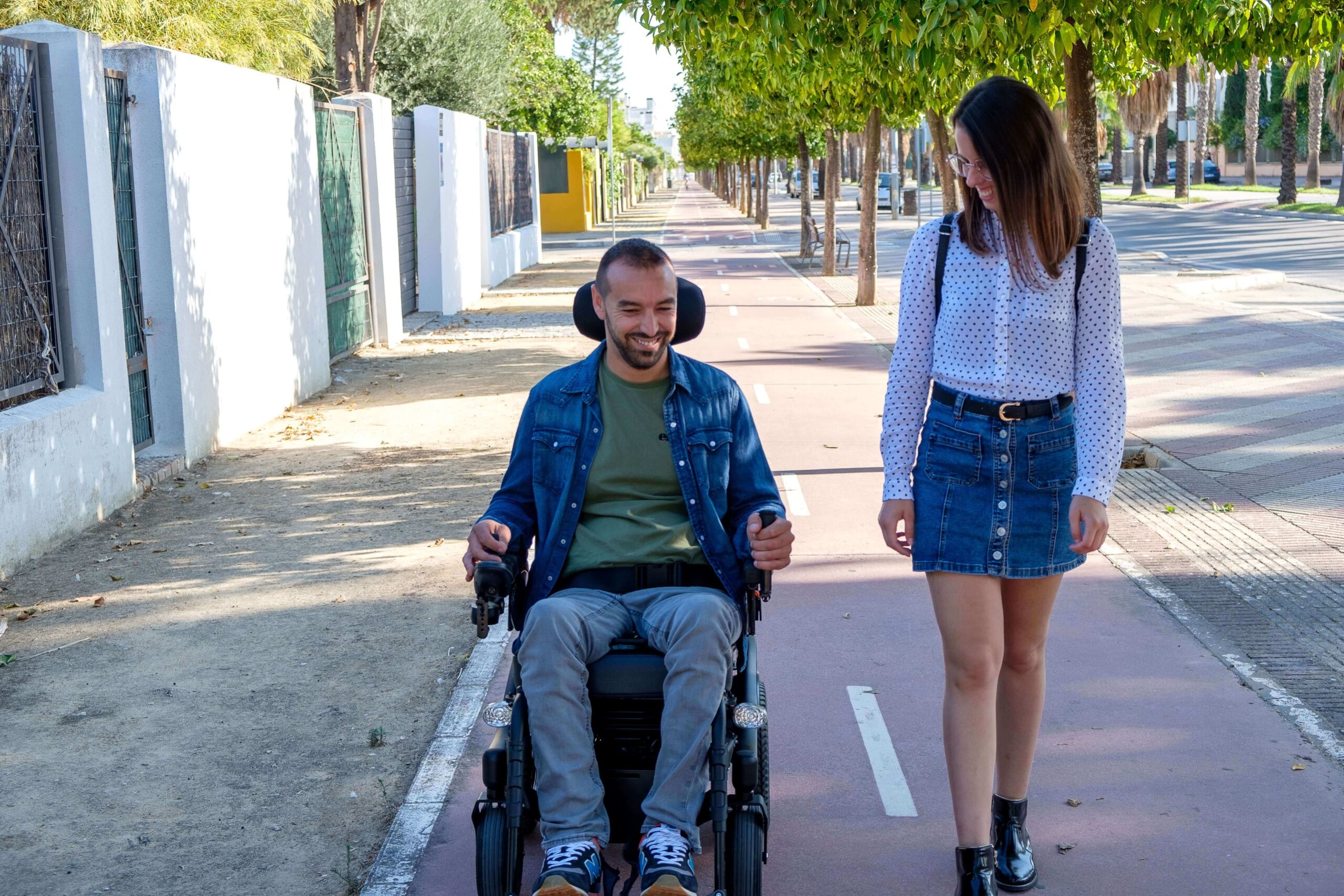 A-man-in-a-power-wheelchair-moving-on-the-street-with-his-friend